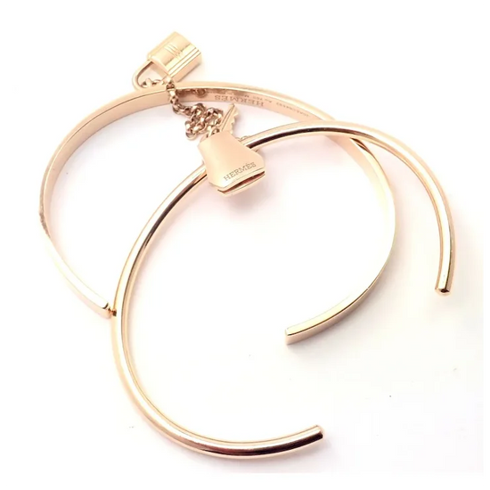 Gold bracelet with a heart-shaped clasp on a white background