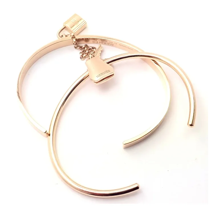 Gold bracelet with a heart-shaped clasp on a white background