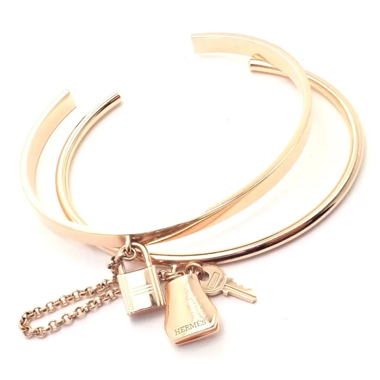 Rose gold bracelet with charms on a white background