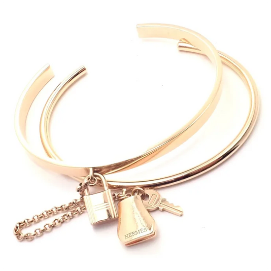 Rose gold bracelet with charms on a white background