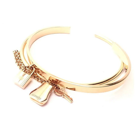 Gold bracelet with charms on a white background