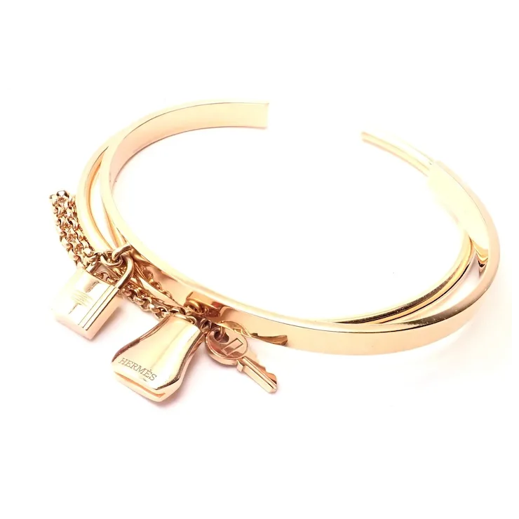 Gold bracelet with charms on a white background