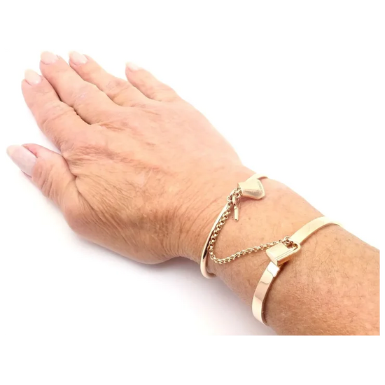 Hand wearing a gold bracelet on a white background
