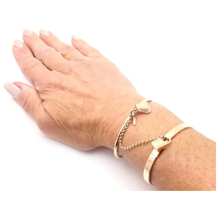 Hand wearing a gold bracelet on a white background