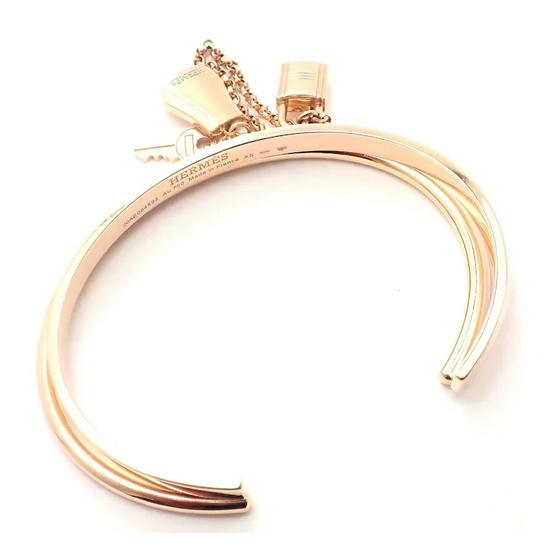 Gold bracelet with a tag on a white background