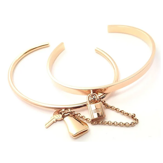 Rose gold bracelet with charms on a white background