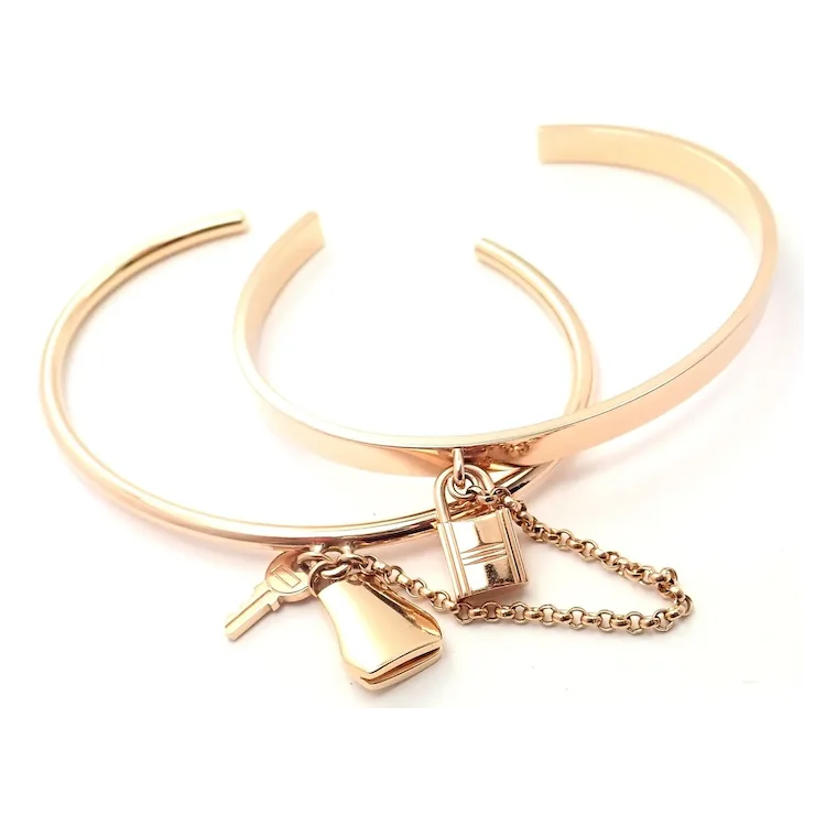 Rose gold bracelet with charms on a white background