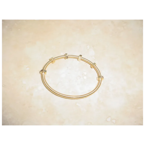 Gold bracelet on a beige background