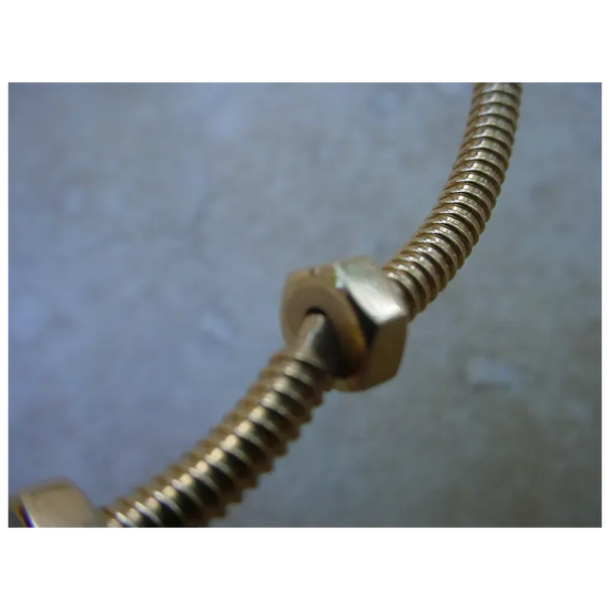 Metallic hose with a fitting on a textured gray background