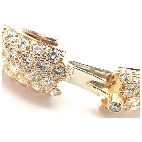 Gold earring with clear gemstones on a white background