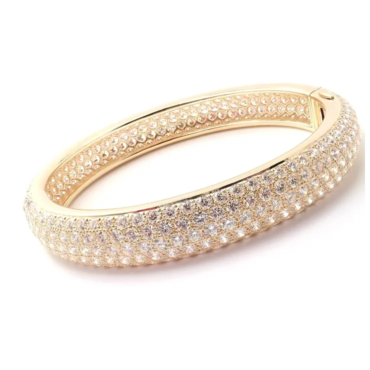 Gold bracelet with diamond accents on a white background