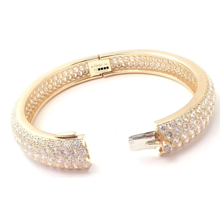 Gold bracelet with diamond accents on a white background