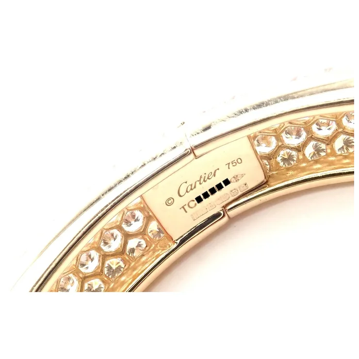 Gold bracelet with diamond accents and Cartier branding on a white background