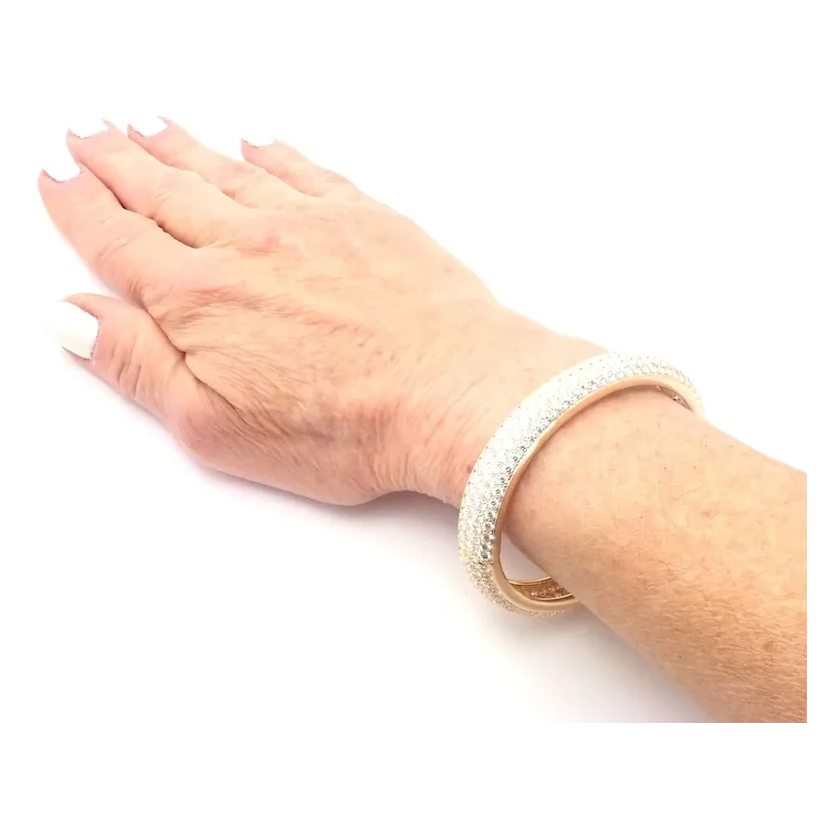 Hand wearing a gold bracelet on a white background
