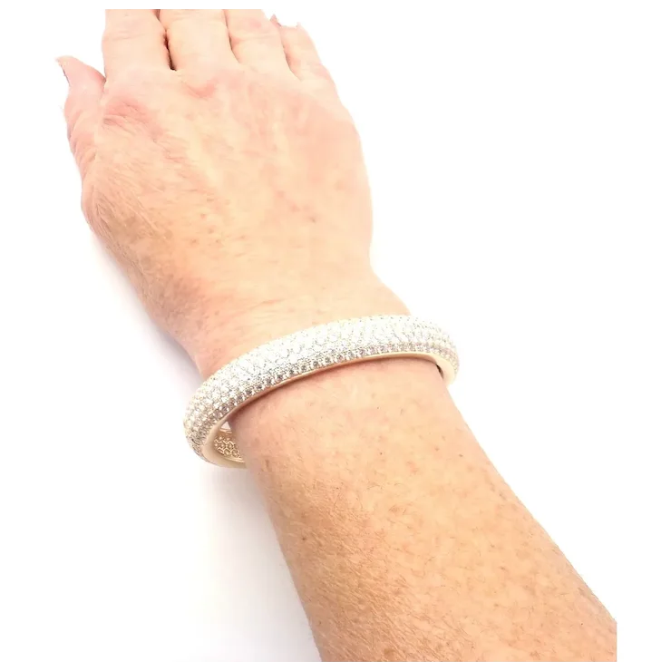 Silver bracelet on a wrist against a white background