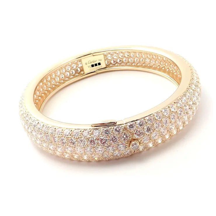 Gold bracelet with clear gemstones on a white background