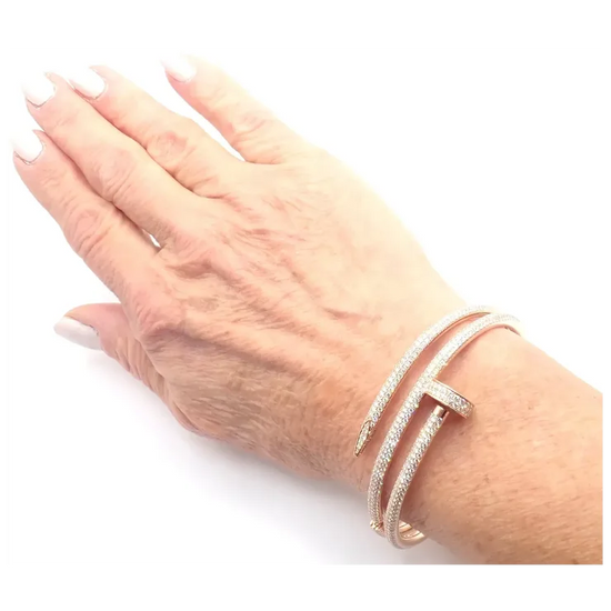 Hand wearing a rose gold bracelet on a white background