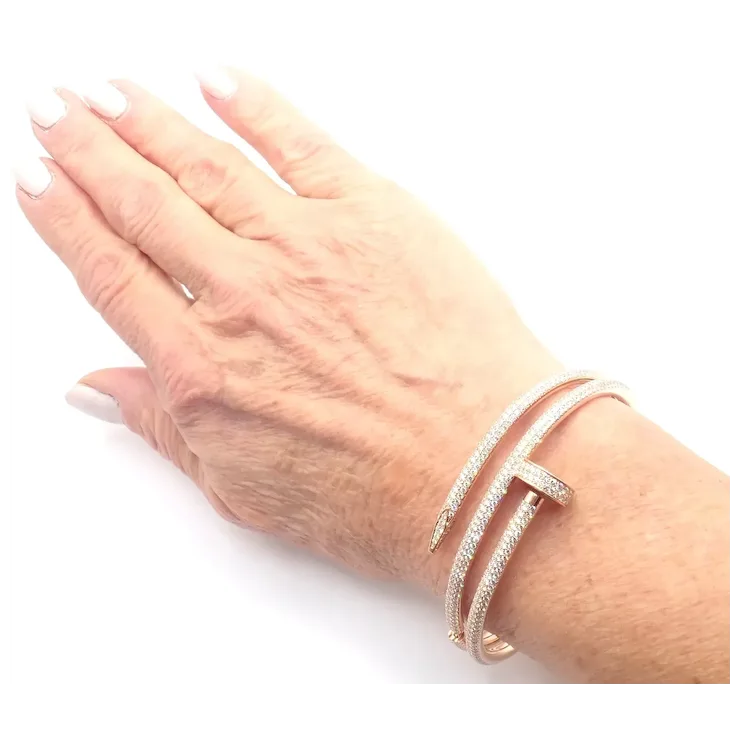 Hand wearing a rose gold bracelet on a white background