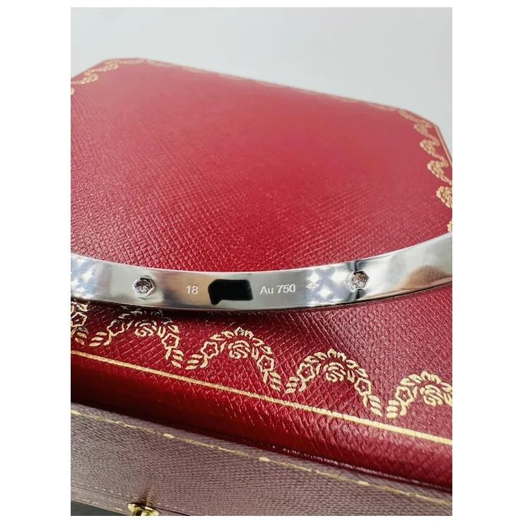 Red jewelry box with silver band and 'Au 750' marking on a white background