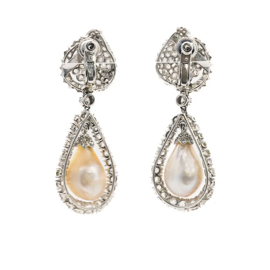 Pair of teardrop-shaped pearl earrings with silver and gemstone detailing on a white background