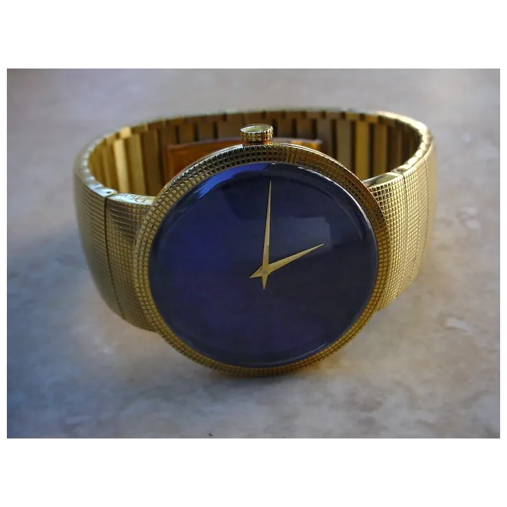 Gold watch with a blue face on a marble surface