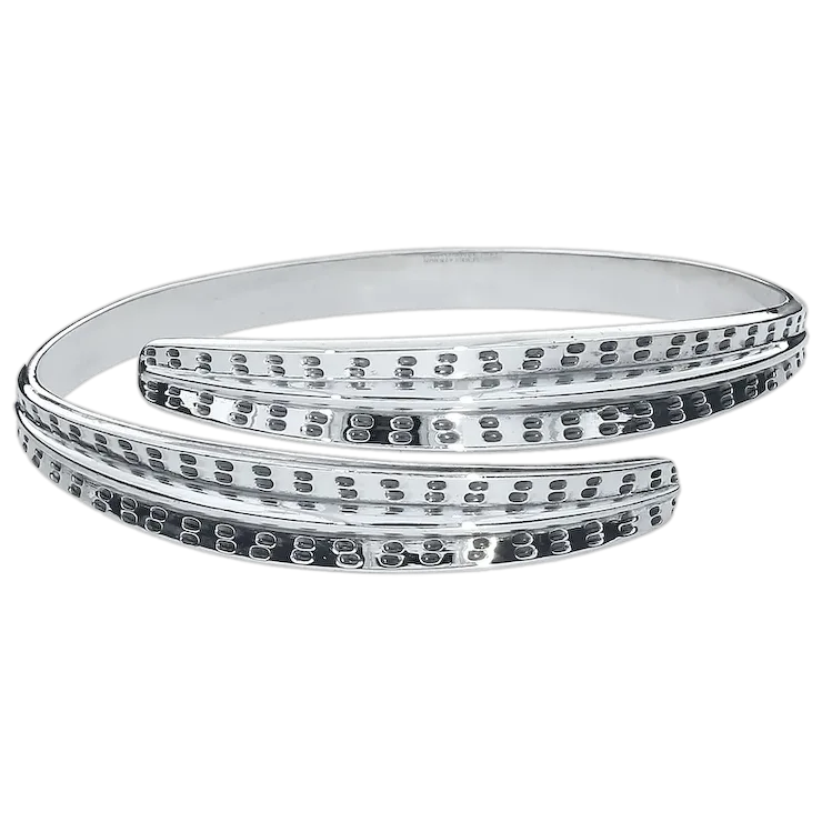 Silver bangles with intricate designs on a white background