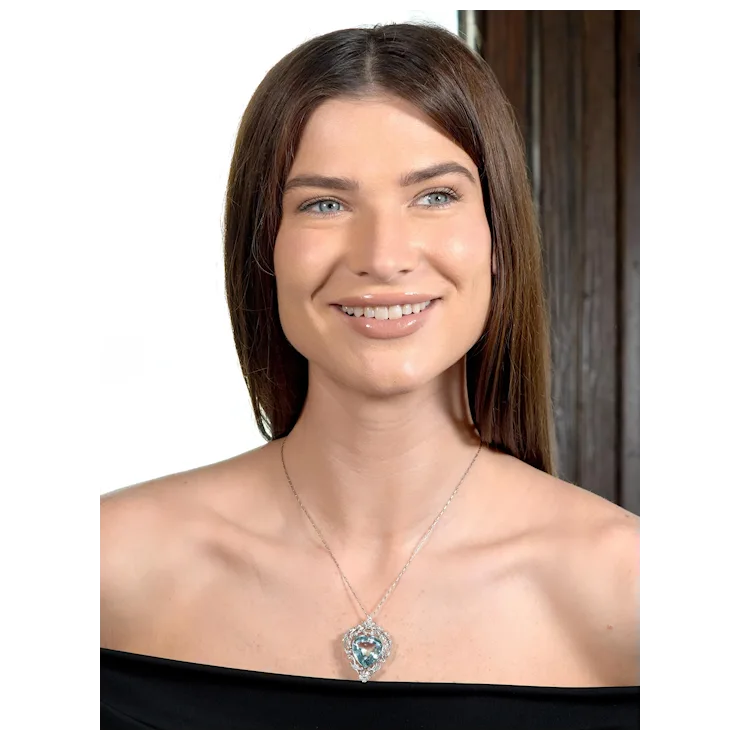Woman wearing a necklace with a pendant on a plain background