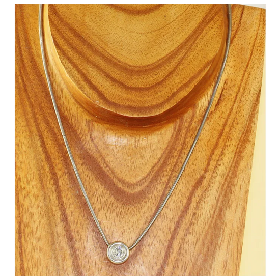 Necklace with a round pendant on a wooden surface