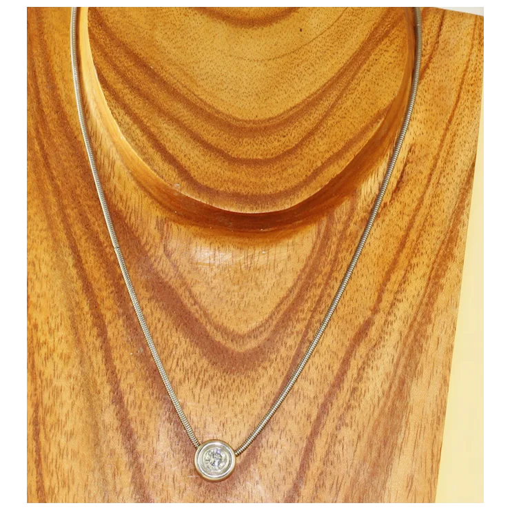 Necklace with a round pendant on a wooden surface