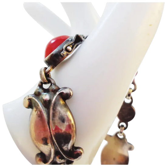 Decorative ring with a red gemstone and gold-like accents on a white stand.