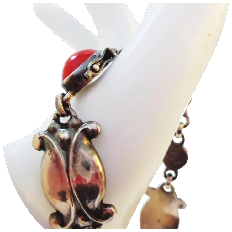 Decorative ring with a red gemstone and gold-like accents on a white stand.