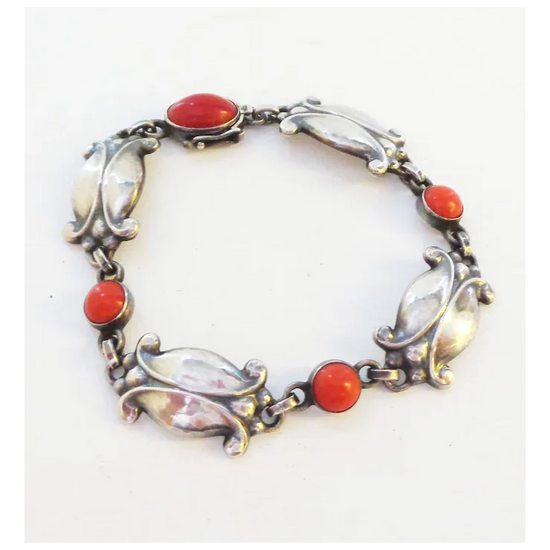 Silver bracelet with red and clear stones on a white background