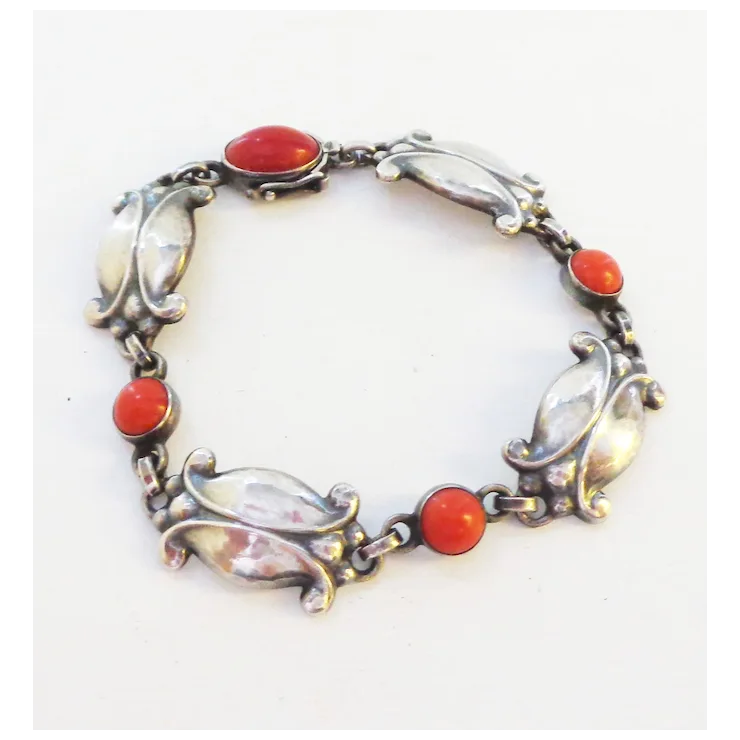 Silver bracelet with red and clear stones on a white background