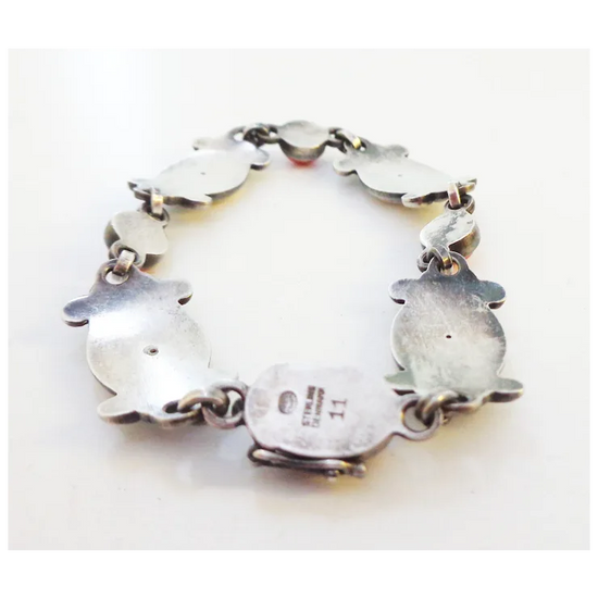 Silver bracelet with heart-shaped charms on a white background