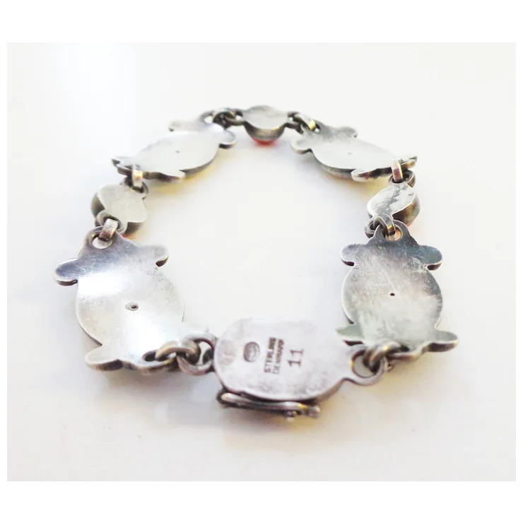 Silver bracelet with heart-shaped charms on a white background
