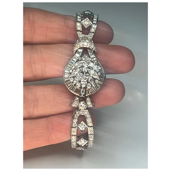 Diamond pendant held between fingers against a neutral background