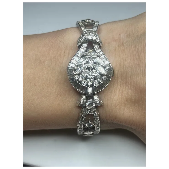 Silver bracelet with a large central gemstone on a wrist against a neutral background
