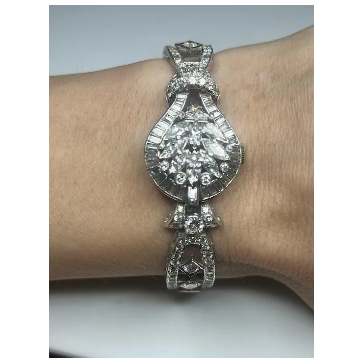 Silver bracelet with a large central gemstone on a wrist against a neutral background
