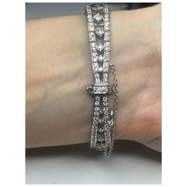 Silver bracelet with clear stones on a wrist against a neutral background