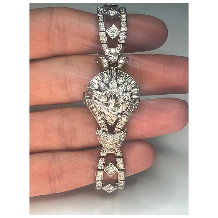 Diamond-encrusted necklace held between fingers against a neutral background