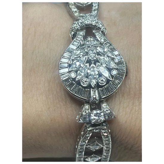 Diamond bracelet on a person's wrist with a plain background