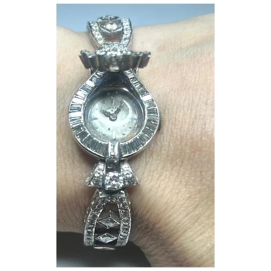 Silver wristwatch with decorative band on a wrist