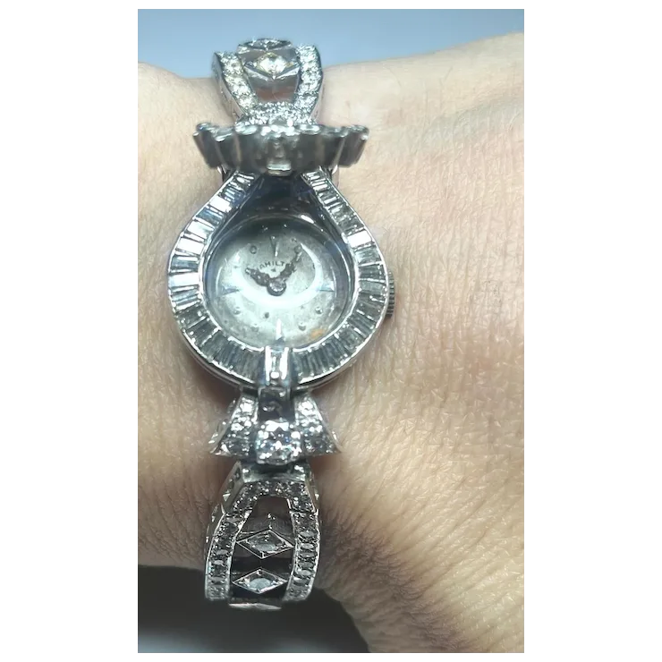 Silver wristwatch with decorative band on a wrist