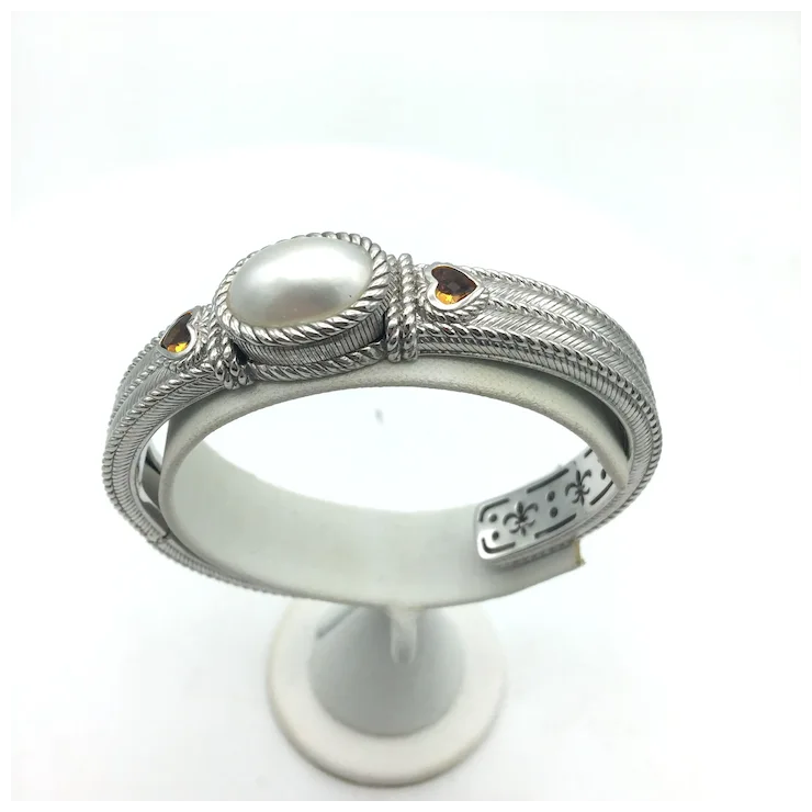 Silver ring with a pearl on a white stand