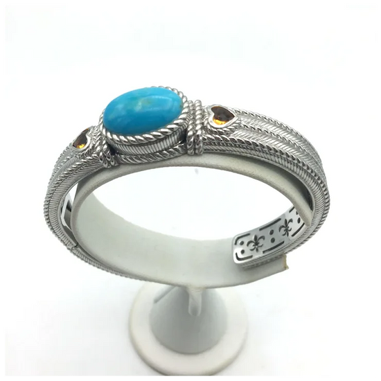 Silver ring with turquoise stone on a white stand
