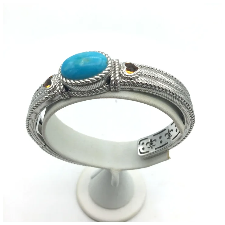 Silver ring with turquoise stone on a white stand