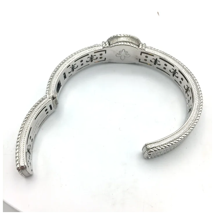 Silver bracelet with intricate design on a white background