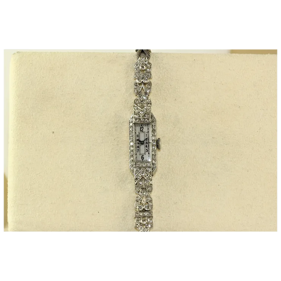 Vintage diamond-encrusted watch on a beige background