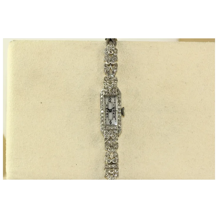 Vintage diamond-encrusted watch on a beige background