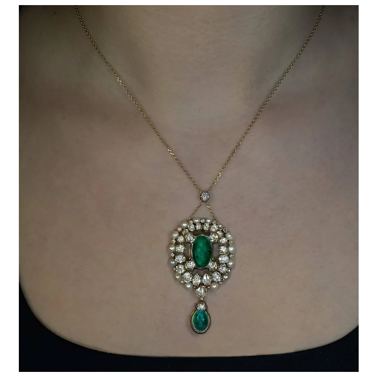 Necklace with emerald and diamond pendant on a person's neck